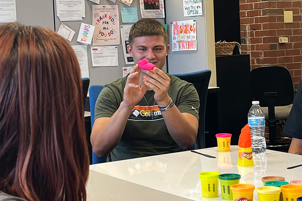 Students play with clay during a Summer Academy event