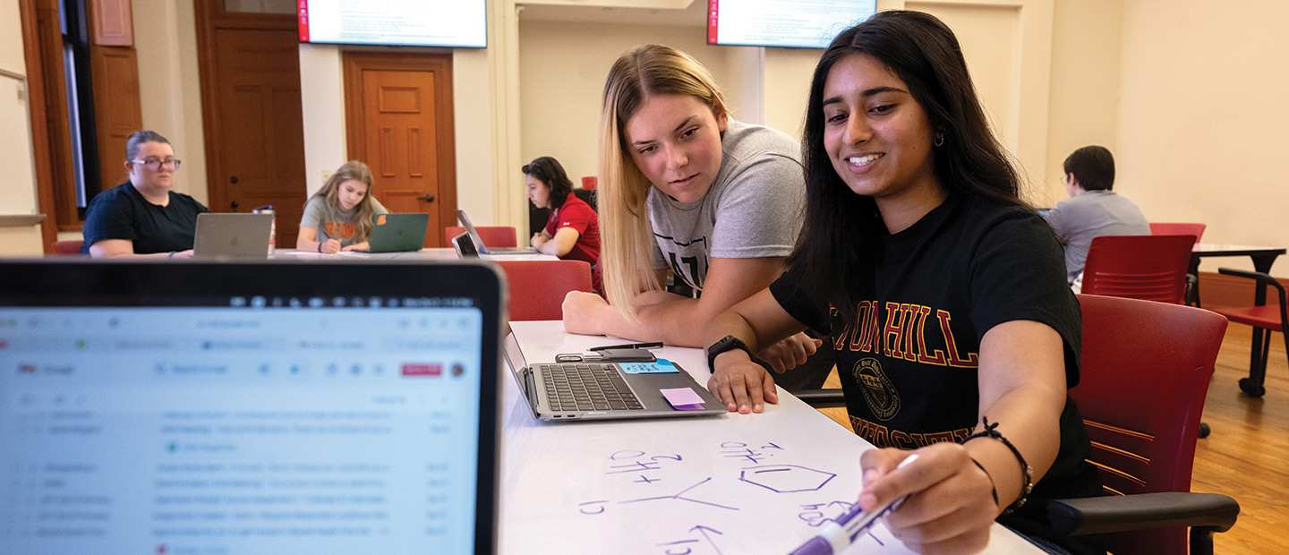 Students work around a whiteboard table