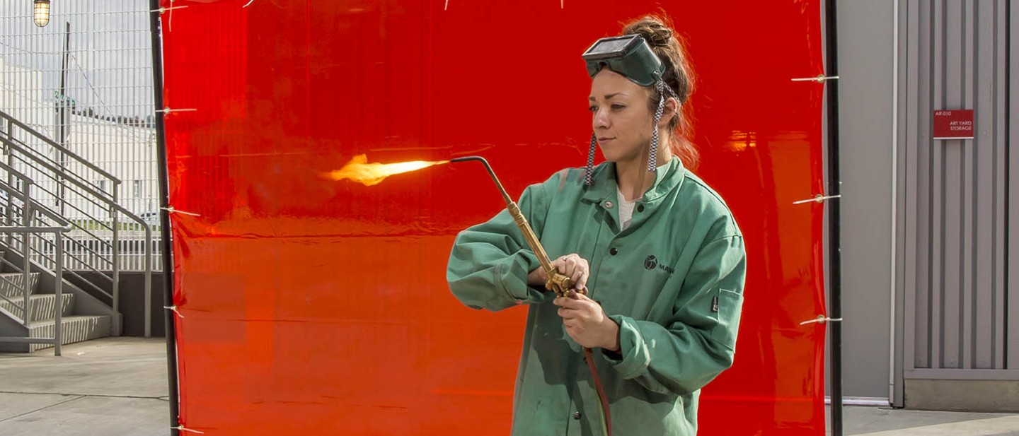 Seton Hill Student adjusting the flame on a welding torch.