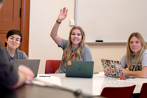 Smiling student raising her hand