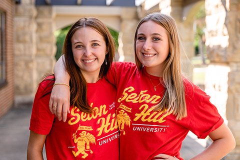 Two students wearing red Seton Hill t-shirts