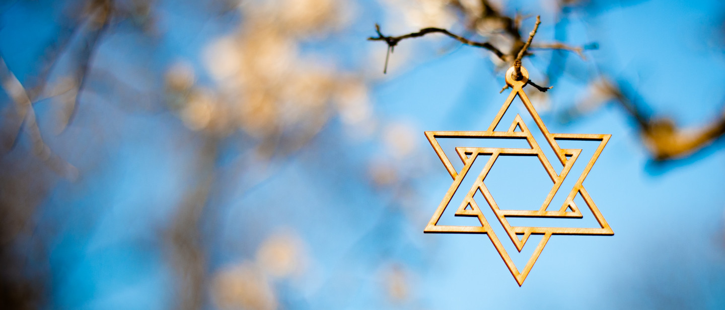 photo of a star of david symbol with trees in the background