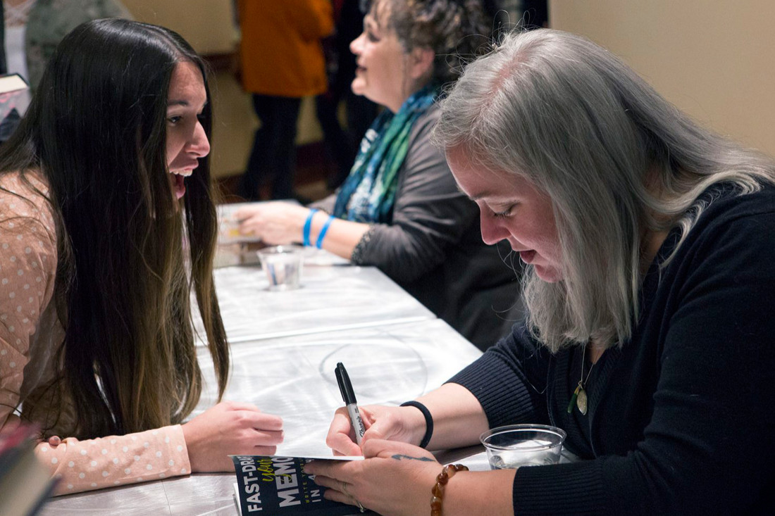 Student Demi Schwartz has a book signed by author R.H. Herron during a residency event.