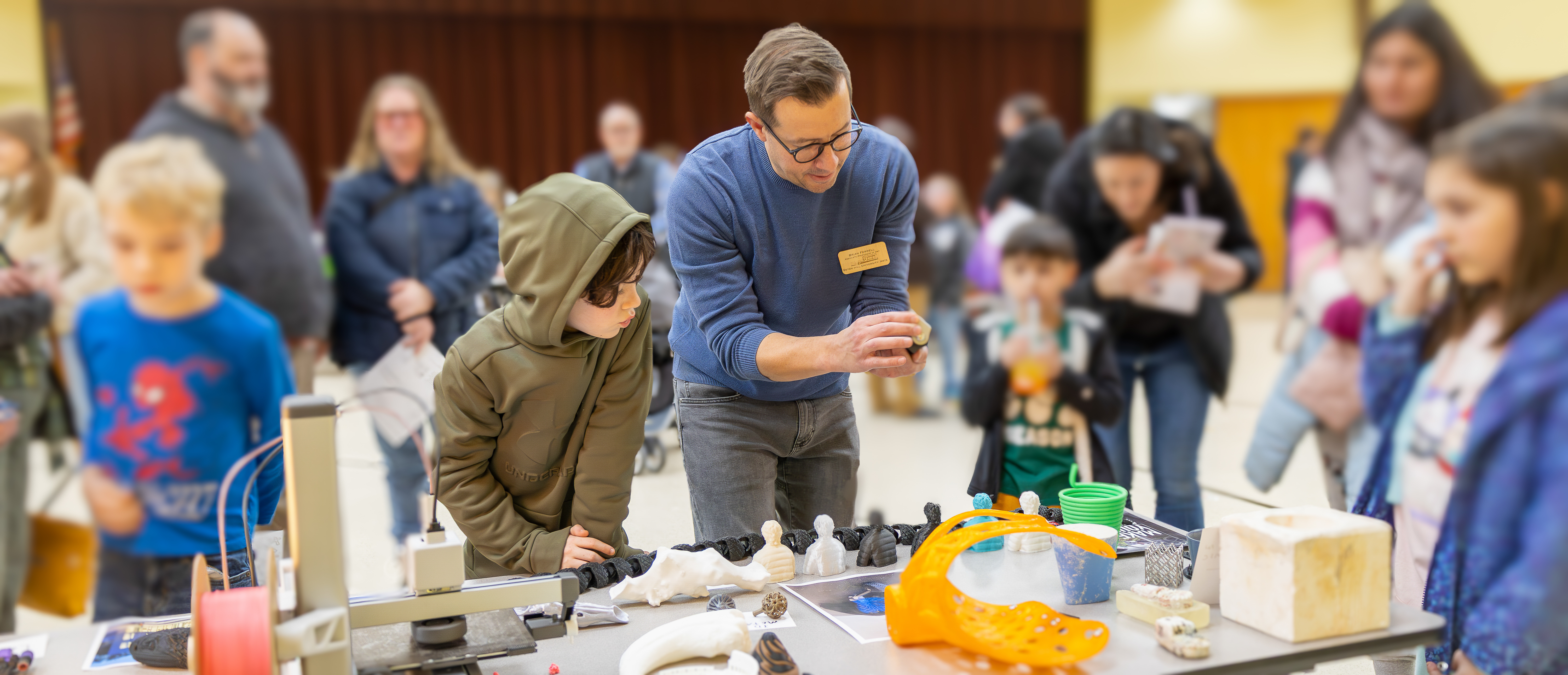 Associate Professor Art Brian Ferrell show off his 3D printed creations at the Nicely Elementary School Science Fair.