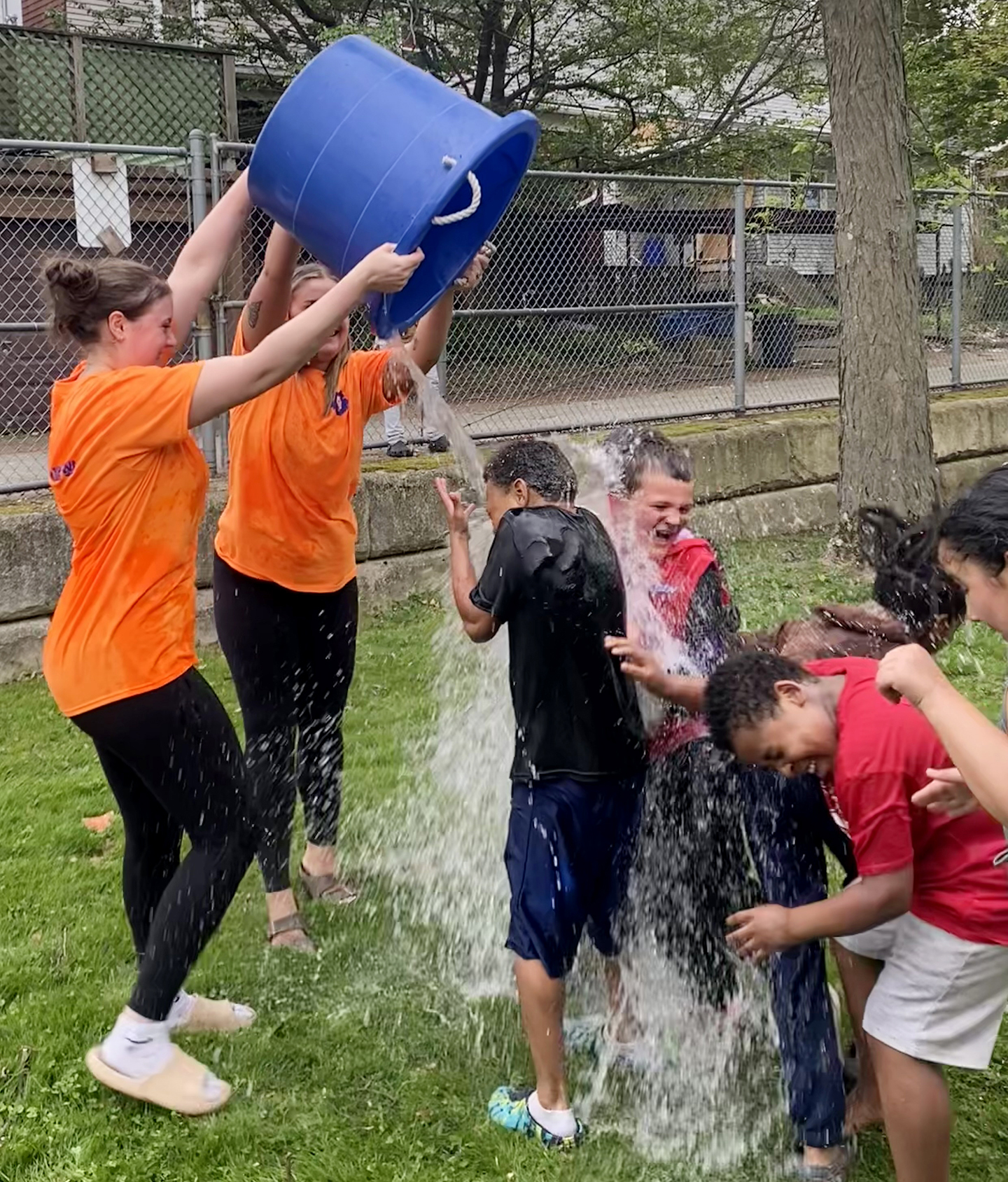 student dump a bucket of water on children at an event